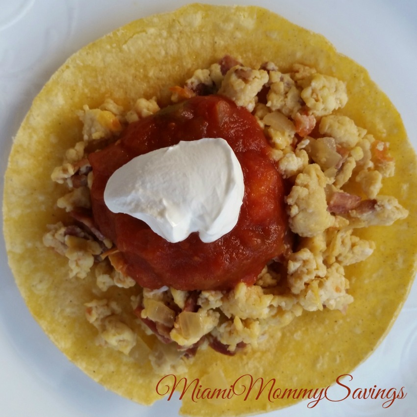 Breakfast tacos made with crispy bacon, scrambled eggs, tomatoes and salsa are the perfect lunch or early dinner option. Enjoy this Easy Scrambled Eggs and Bacon Tacos Recipe that everyone would love. FIind the recipe at CleverlyMe.com